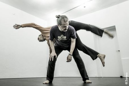 dos bailarines haciendo contact, uno encima del otro