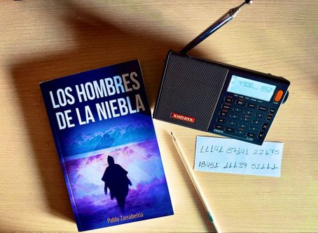 Foto de la novela "los hombres de la niebla" encima de una mesa con una calculadora