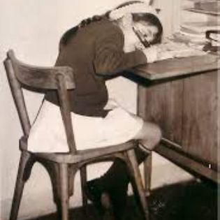Niña escribiendo en un pequeño escritorio de madera